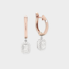 Rose gold hoop earrings with diamond drop pendants on a light gray background