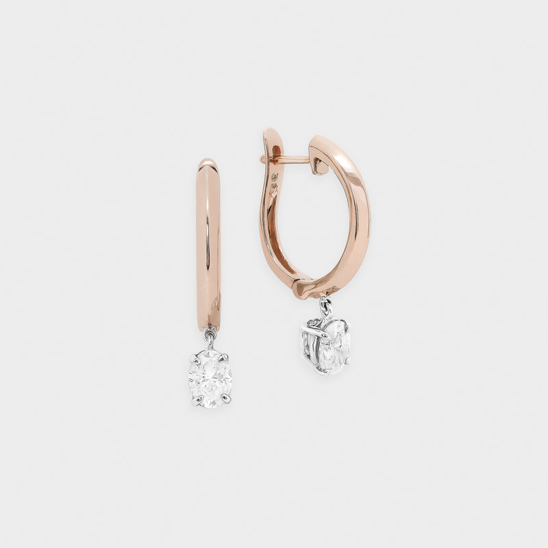 Rose gold hoop earrings with diamond drops on a light gray background