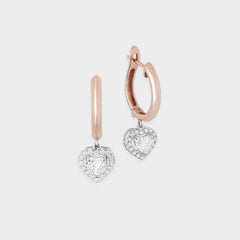 Heart-shaped earrings with rose and white gold finish on a light gray background