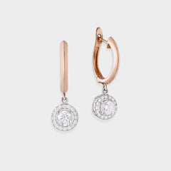 Rose gold hoop earrings with diamond drop on a light gray background