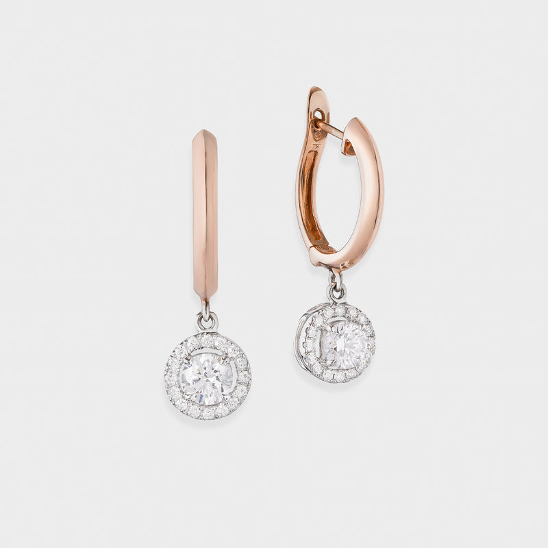 Rose gold hoop earrings with diamond drop on a light gray background