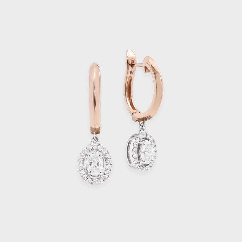 Rose gold hoop earrings with diamond drops on a light gray background