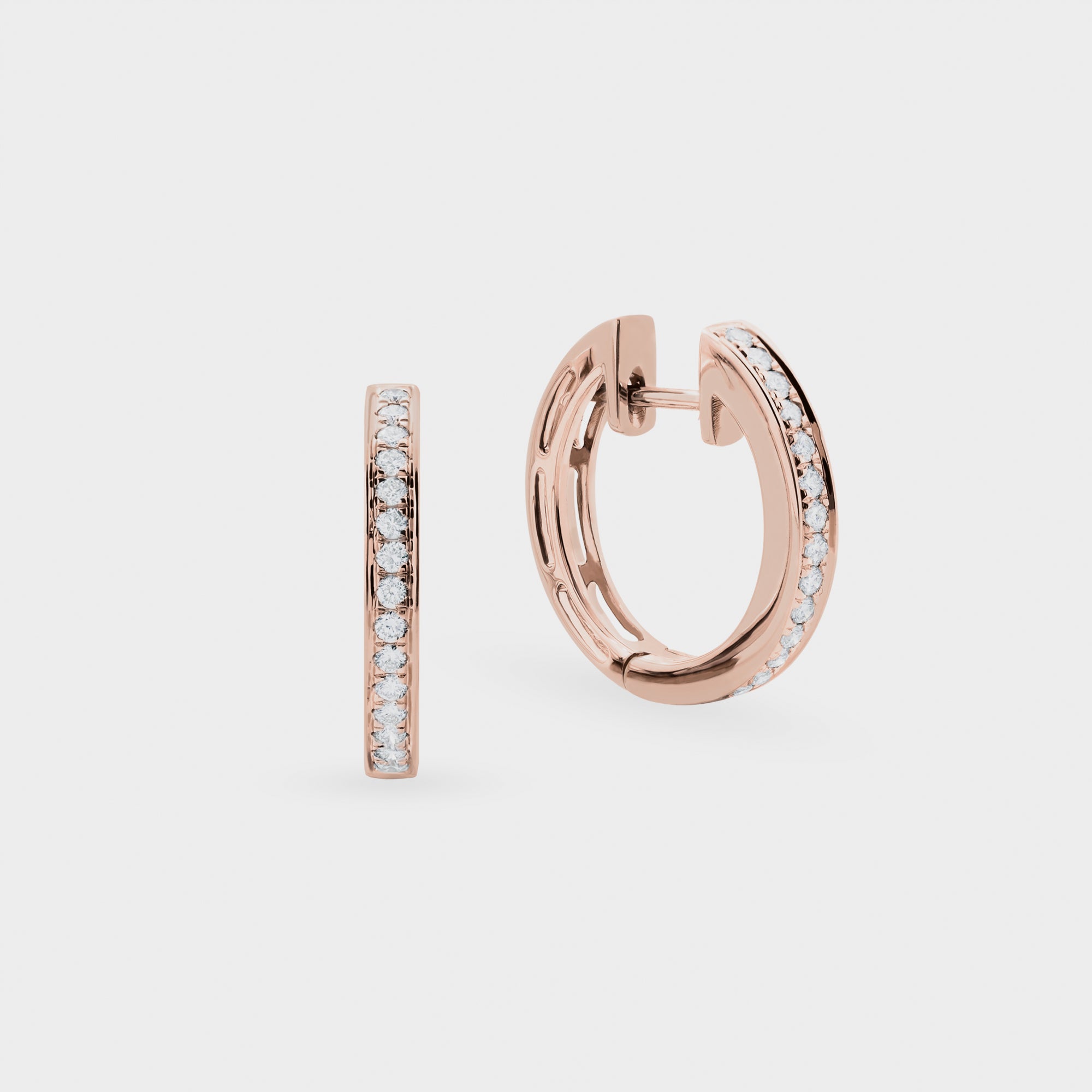 Rose gold hoop earrings with embedded diamonds on a light gray background