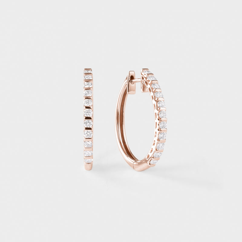 Rose gold hoop earrings with clear gemstones on a light gray background