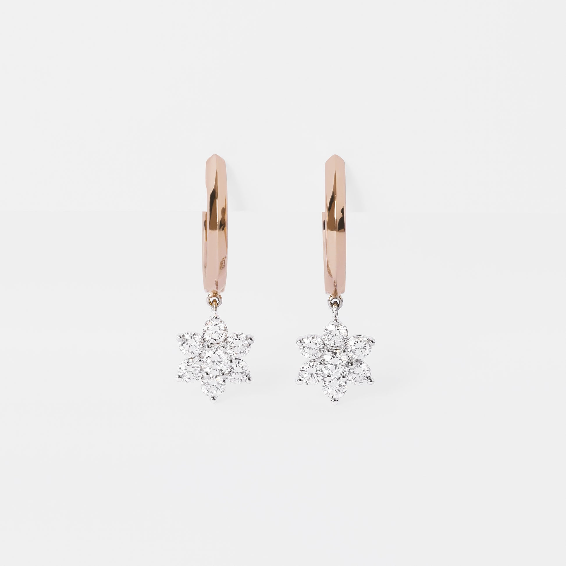 Rose gold hoop earrings with diamond Sunflower pendants on a light gray background