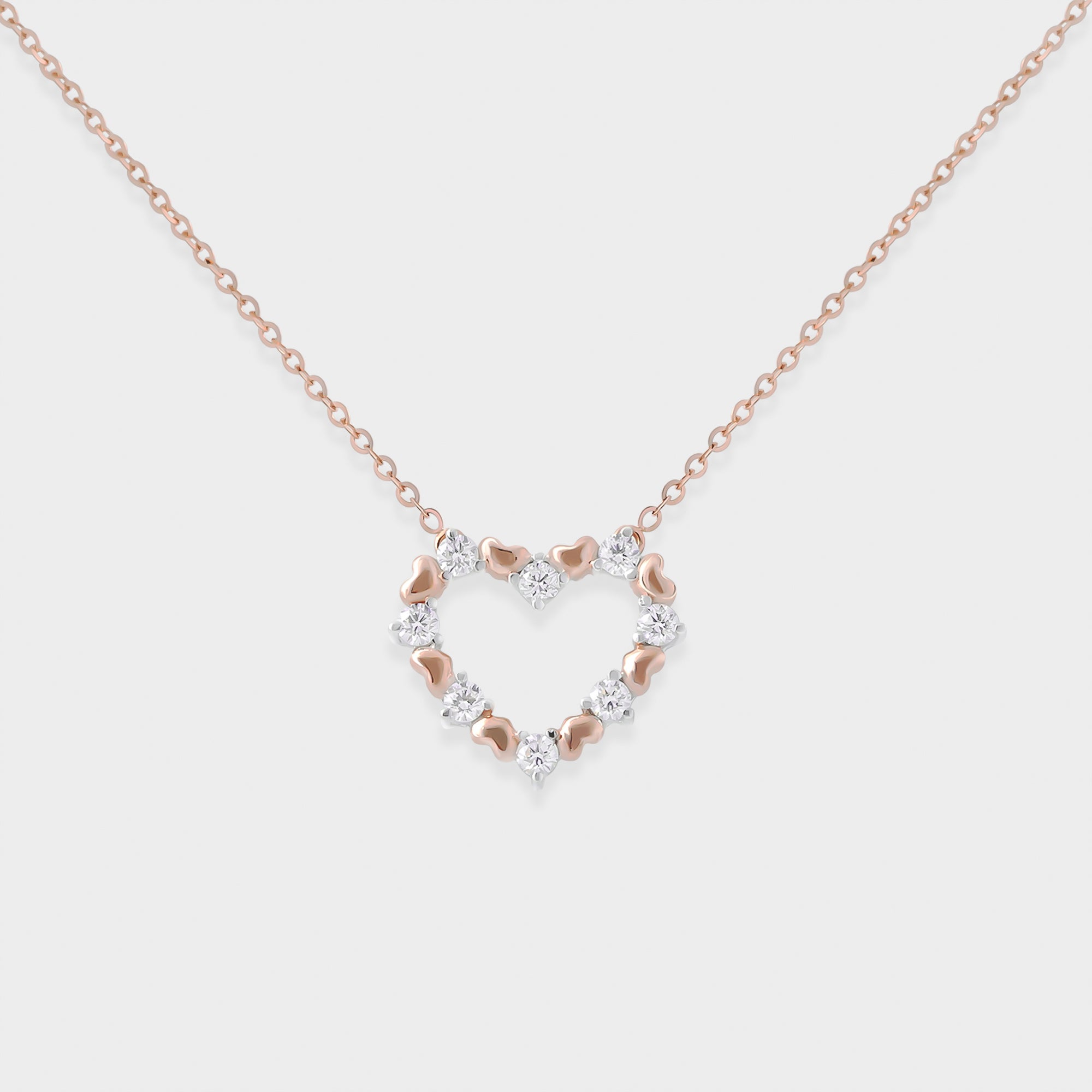 Two-tone necklace with heart-shaped pendant on a light grey background